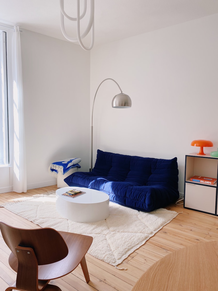 a living room with a blue couch and a white rug